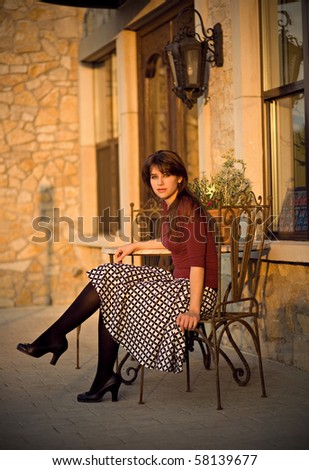 Classic Young Woman sitting outside a Cafe