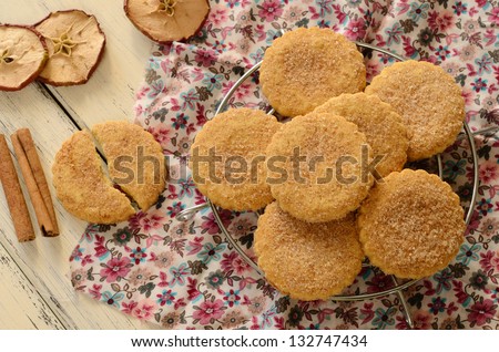 Apple cookies powdered with sugar and cinnamon on wooden table