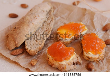 Sandwiches with butter and apricot jam on piece of paper
