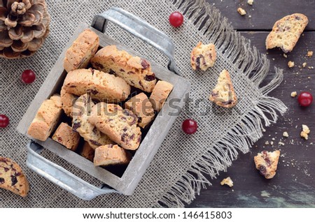 Cranberry biscotti in decorative crate on linen napkin on rusted wooden table