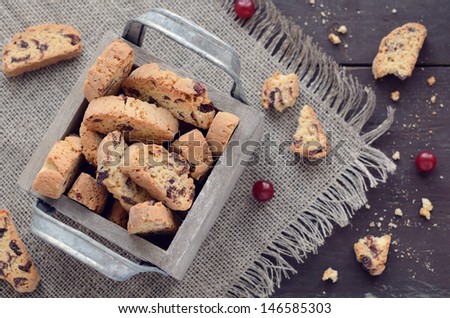 Cranberry biscotti in decorative crate on linen napkin on rusted wooden table