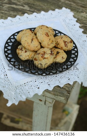 Homemade walnut cookies on vintage lace doily on rusted wooden table