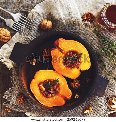 Quince baked with honey, walnut and thyme in clay baking pan on rustic background, square