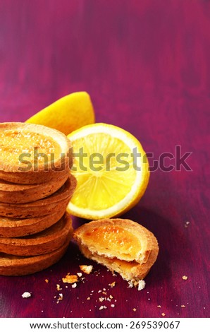 Small lemon tartlets with empty space on deep lilac background