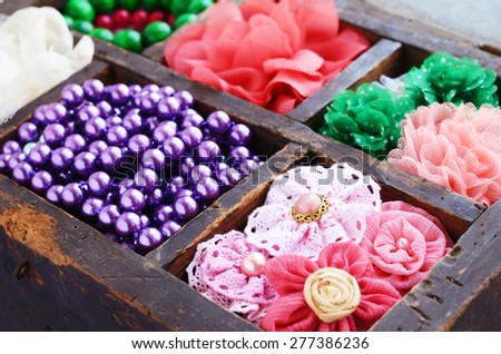 Collection of colorful brooches, beads and hair pins in wooden box