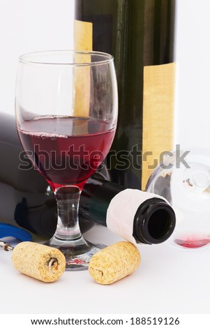 The After the Party Mess. Glass and Empty Bottle of Red Wine and Cork Opener on a White Background. Close up.