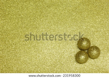 Background Filled with Shiny Gold Glitter and Three Golden Balls.