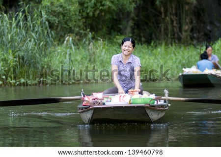 NINHBINH, VIETNAM, MAY 18: Unidentified woman, own her little shop on boat in Tamcoc on May 18, 2013 in Ninhbinh, Vietnam. Tamcoc is a famous place in Ninhbinh province