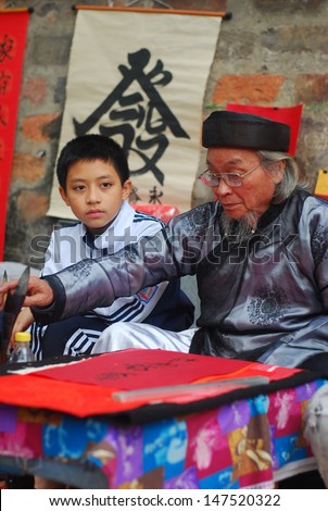 HANOI, VIETNAM, FEBRUARY 14: Old master is writing ancient letter for everyone in lunar new year on February 14, 2013 in Hanoi, Vietnam. This is a tradition of vietnamese people in lunar new year