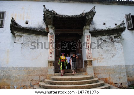 HAGIANG, VIETNAM, APRIL 30: A local tour guide and tourists in King of Meo ethnic minority group\'s house on April 30, 2011 in Hagiang, Vietnam. This is visit place in Hagiang province