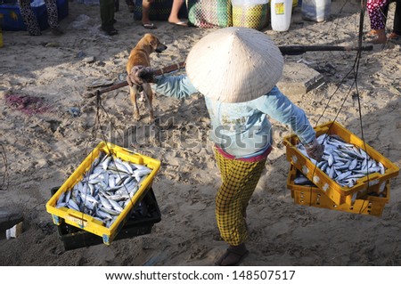 BINHTHUAN, VIETNAM, MAY 4: Unidentified woman sell fishes in a traditional fish market on the beach on May 4, 2013 in Binhthuan, Vietnam. This market only happens in early morning