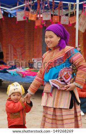 LAOCAI, VIETNAM, FEBRUARY 10: Unidentified ethnic minority woman with her son  in a traditional market on February 10, 2012 in Laocai, Vietnam. There are many ethnic minority groups in Laocai