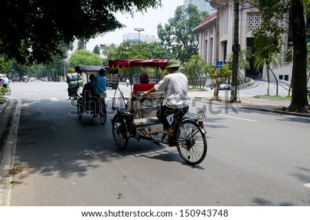 HANOI, VIETNAM, AUGUST 11: Cyclos drivers carry tourists on August 11, 2013 in Hanoi, Vietnam. Cyclo used to be a popular transportation in Vietnam, it is for tourism now