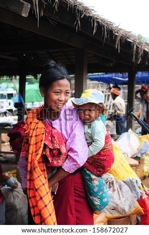 INLE LAKE, MYANMAR, SEPTEMBER 5: An Burmese ethnic minority woman with her son, Shan, 1 year old on September 5, 2013 in Inle Lake, Myanmar. There are 8 ethnic minority group in Inle lake area
