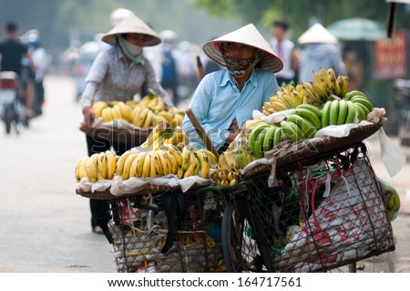 HANOI, VIETNAM - NOVEMBER 3: Unidentified street vendor with fruits in street on November 3, 2013 in Hanoi, Vietnam. This is a specific tradition in Hanoi