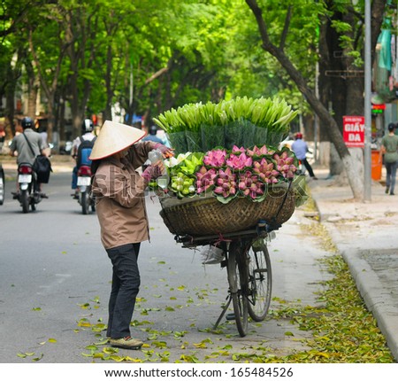 HANOI, VIETNAM - JUNE 16: Unidentified flower vendor in a street in Hanoi on June 16, 2012 in Hanoi, Vietnam. This is a specific tradition in Hanoi