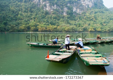 NINHBINH, VIETNAM, JANUARY 4: Unidentified boat owners wait for tourists visit Trang An grottoes on January 4, 2014 in Ninhbinh, Vietnam.  Trang An grottoes are famous place in Ninhbinh province