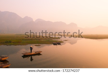 NINHBINH, VIETNAM, JANUARY 4: Unidentified boatman on boat in Van Long Natural Reserve on January 4, 2014 in Ninhbinh, Vietnam. Van Long Natural Reserve is famous place in Ninhbinh province