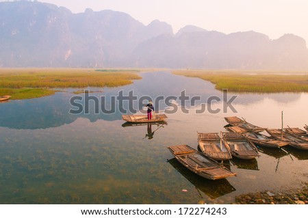 NINHBINH, VIETNAM, JANUARY 4: Unidentified boatman on boat in Van Long Natural Reserve on January 4, 2014 in Ninhbinh, Vietnam. Van Long Natural Reserve is famous place in Ninhbinh province