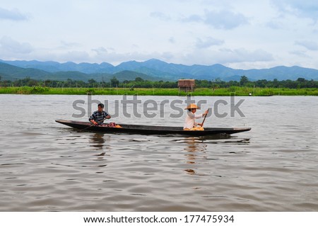 INLE LAKE, MYANMAR - SEPTEMBER 6 : Two unidentified people on a boat to market on September 6, 2013 in Inle Lake, Myanmar. They live in a village on lake.