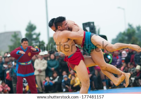 HANOI, VIETNAM, FEBRUARY 16: Two wrestlers in a match in traditional wrestling championship on February 16, 2014 in Hanoi, Vietnam. Wrestling is a traditional sport in Vietnam