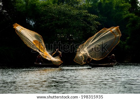 HUE, VIETNAM, MAY 2: An unidentified fishing men are throwing fishing net on May 2, 2014 in Hue, Vietnam. Hue, a UNESCO World Heritage site.