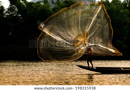 HUE, VIETNAM, MAY 2: An unidentified fishing man is throwing fishing net on May 2, 2014 in Hue, Vietnam. Hue, a UNESCO World Heritage site.