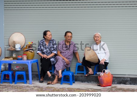HANOI, VIETNAM - JUNE 11: Unidentified old women seat and talk with each other in tea street vendor on June 11, 2014 in Hanoi, Vietnam. In Vietnam, many thing are sold on street by street vendor.