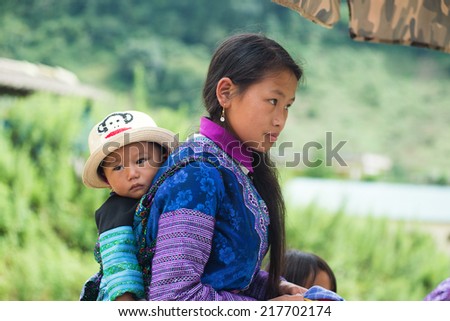 MOCCHAU, VIETNAM, SEPT 2: Unidentified H'mong ethnic minority woman with her son in a festival on September 2, 2014 in Mocchau, Vietnam. This is biggest festival of H'mong ethnic minority people.