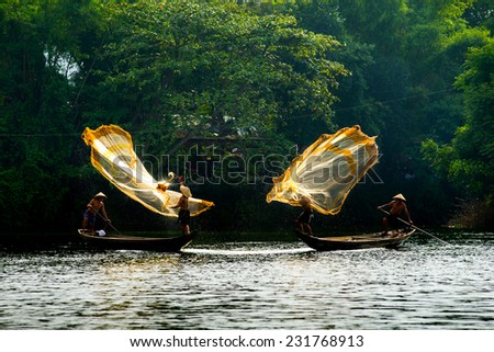 HUE, VIETNAM, MAY 2:Unidentified fishing men are throwing fishing net on May 2, 2014 in Hue, Vietnam. Hue, a UNESCO World Heritage site.