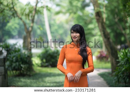 Beautiful vietnamese girl in traditional dress (ao dai) in a park in Hanoi, Vietnam