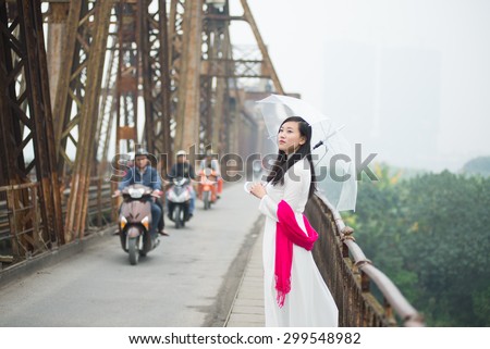 Vietnamese girl on Long Bien bridge in Hanoi, Vietnam. Long Bien bridge is a historic cantilever bridge across the Red River in Hanoi city.