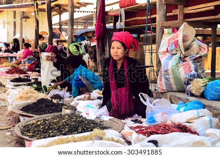 INLE LAKE, MYANMAR, FEB 29, 2015: An ethnic minority woman sell vegetable in a traditional market. There are 8 ethnic minority group in Inle lake area