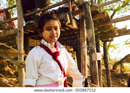INLE LAKE, MYANMAR, SEPTEMBER 5: An unidentified Burmese girl with thanaka on her face on September 5, 2013 in Inle Lake, Myanmar. Thanaka is a yellowish-white cosmetic paste made from ground bark.
