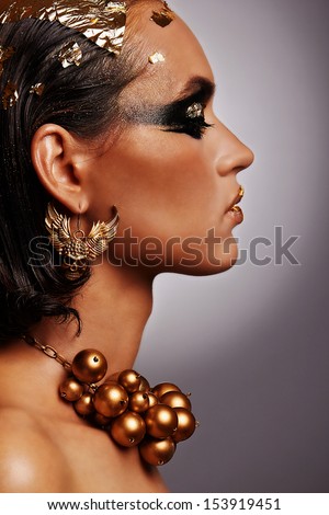 Amazing egyptian golden make-up, Cleopatra style, profile portrait,smokey eyes,golden glamour, shiny, jewelry and art.