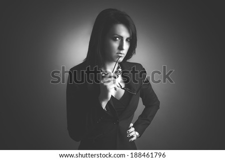 Portrait of a business woman, puzzled, hand on hips and penetrating gaze. Mono effect.