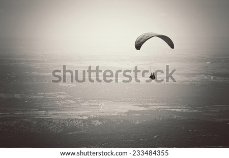Paragliding, flying over El Escorial in Madrid, Spain. Black and white picture.