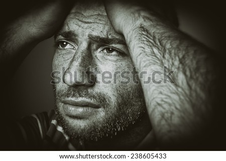 Portrait of a stressed young man with head in hands. Old style picture.