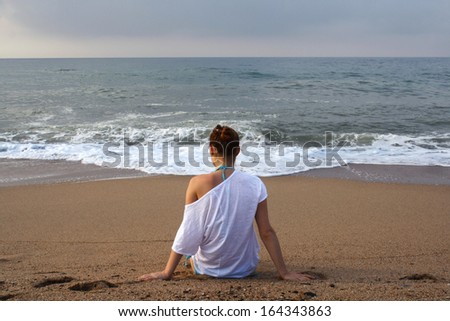 girl sitting on the shore of sea morning dawn