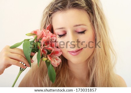 Romantic cute woman with pink flowers portrait in natural warm colors