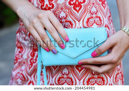 blue clutch detail pink manicure with young woman in fashion dress