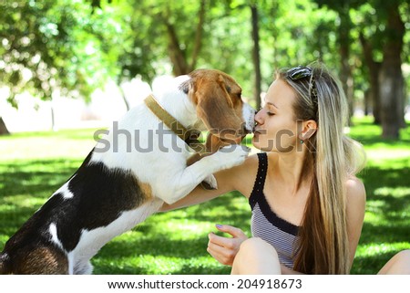 Outdoors portrait happy woman with a dog beagle playing on nature