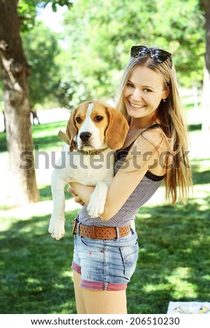 Portrait  happy smiling woman with her beagle dog in green park outdoors summer