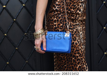 fashion girl with blue handbag in leopard dress colors and gold accessories outdoor