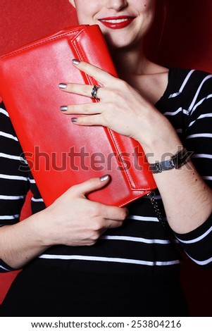 young happy woman with red handbag clutch evening fashion style red background