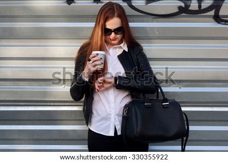 attractive busy woman drink coffee and looking watch outdoor