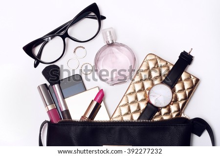 Fashionable female accessories watch glasses lipstick perfume and black purse. Overhead of essentials for modern young woman.