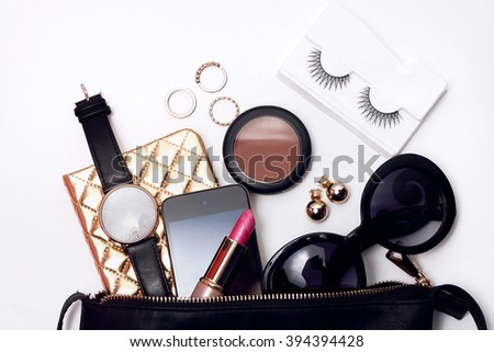 Top view of woman fashion accessories . Trendy sunglasses, black bag , watch , lipstick ,blusher , notebook , smart phone
