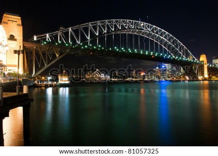 Sydney Harbour Bridge By Night with sparkling water reflection. The Sydney Opera House is at the background.