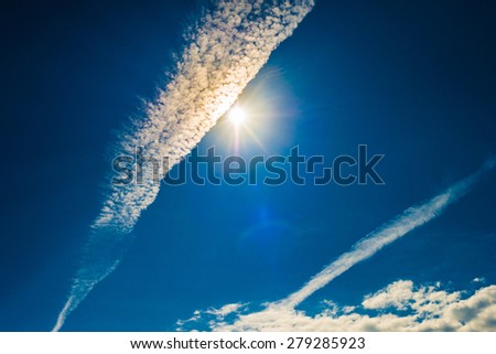Strong sun and skies and clouds with lens flare